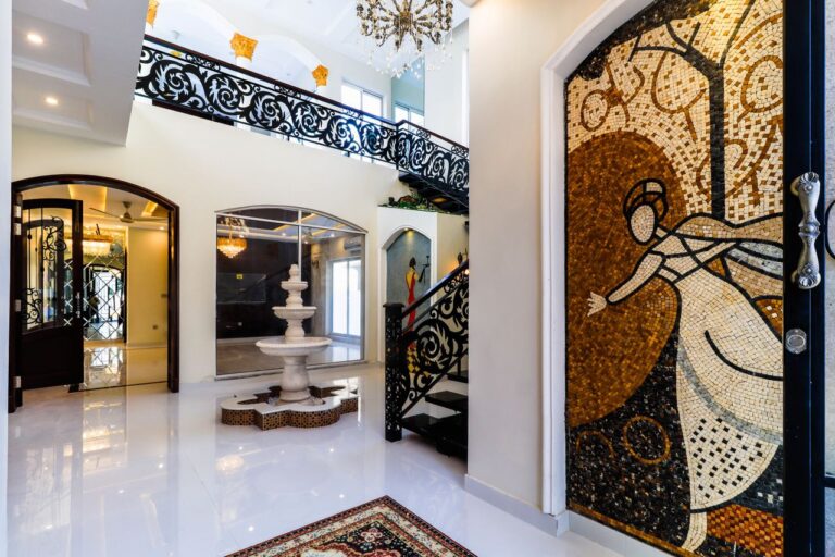 Luxurious interior showcasing artistic mosaics and a marble fountain under ornate railings.